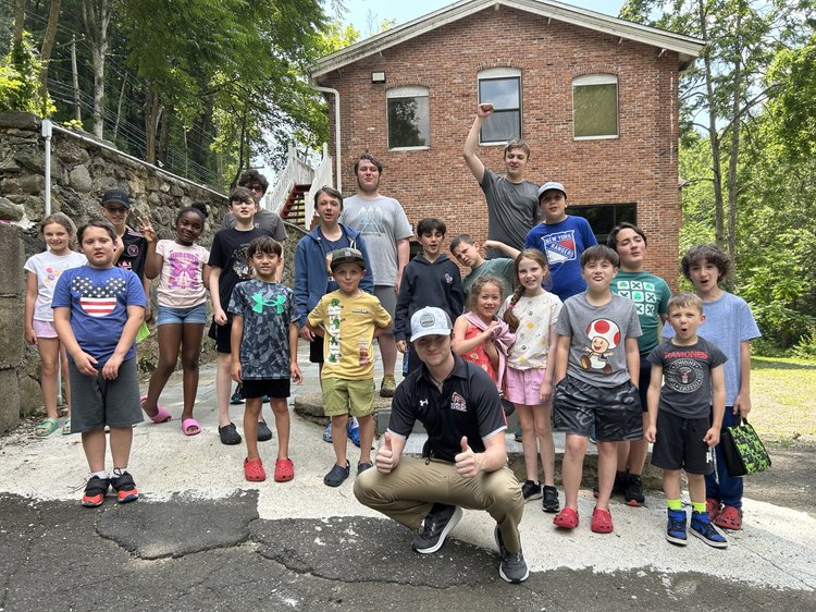A summer camp group outdoors with their counselor